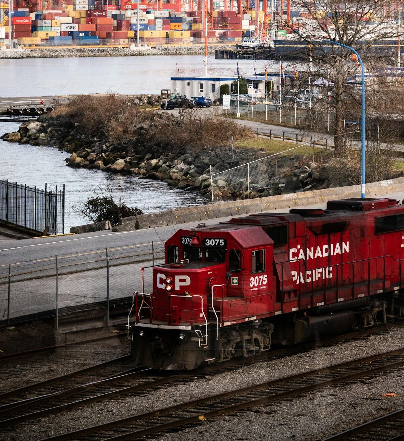 A Canadian Pacific train near container cranes in Vancouver, BC port.